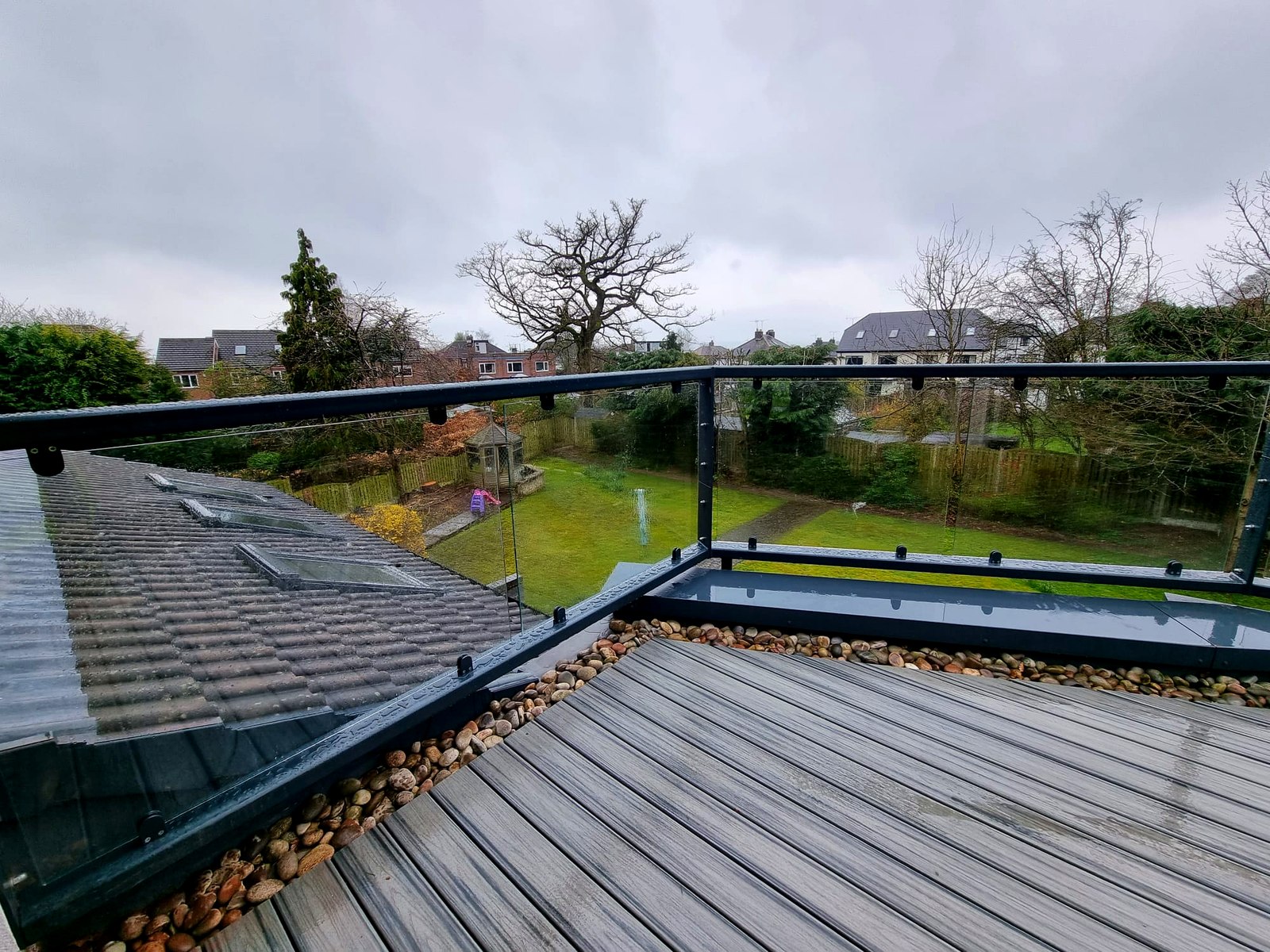 Anthracite grey parapet-wall glass balcony balustrade along an irregular balcony, Norton, Sheffield